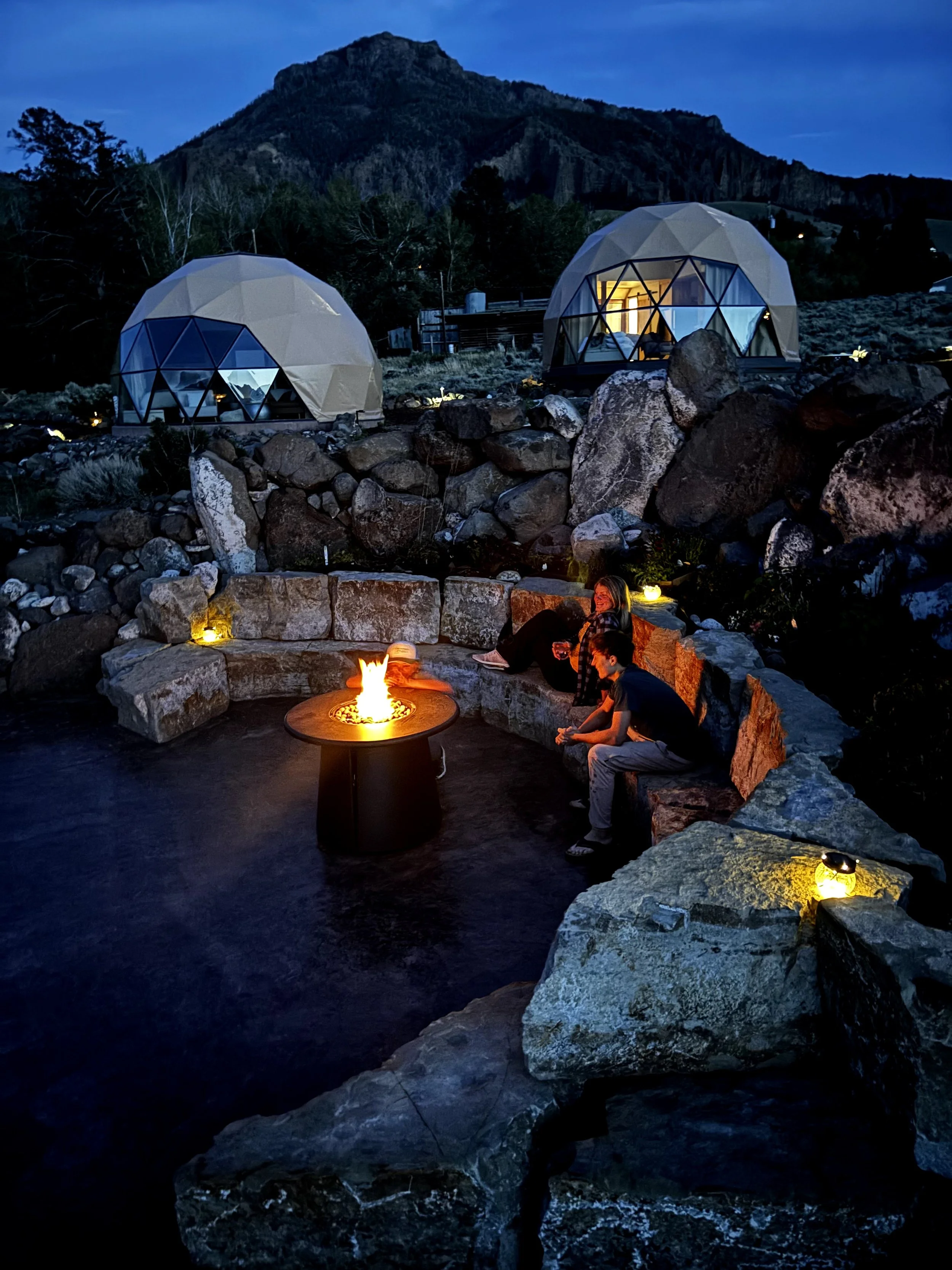 beautiful fire pit for smores and connection, gathering place for groups surrounded by flowers and rocks mountains, star gazing, bbq patio nestled in the domes with expansive night sky 