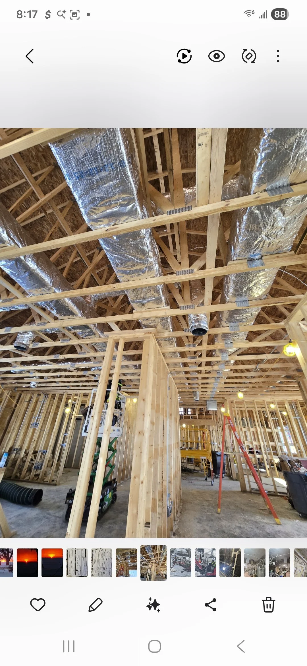 Interior view of a building under construction with exposed wooden framing and HVAC ductwork installed in the ceiling.