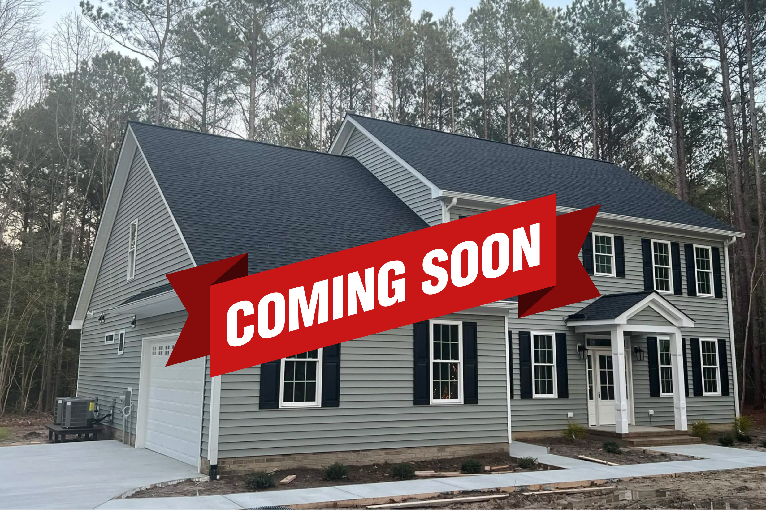 New two-story house with gray siding, black shutters, and white trim, located near a wooded area.