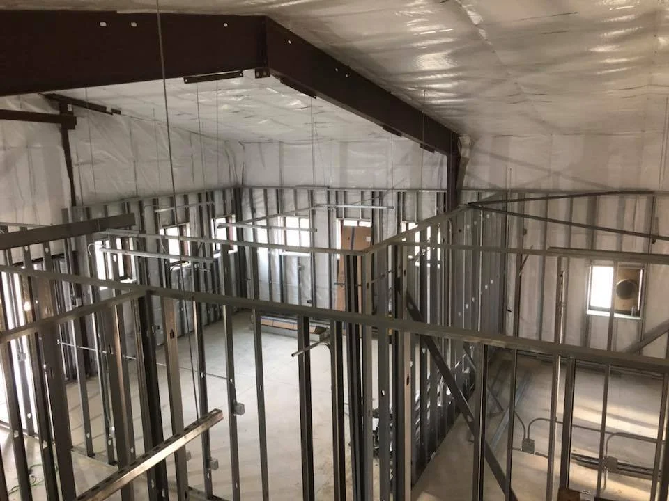 Construction site with metal framing for interior walls inside a building under construction.