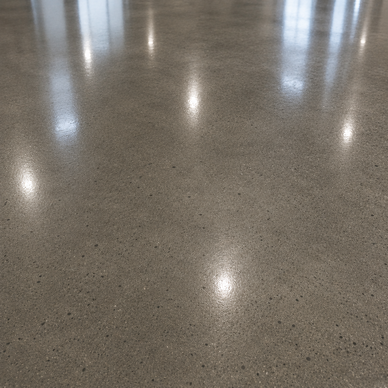 Polished concrete floor with reflections of overhead lights.