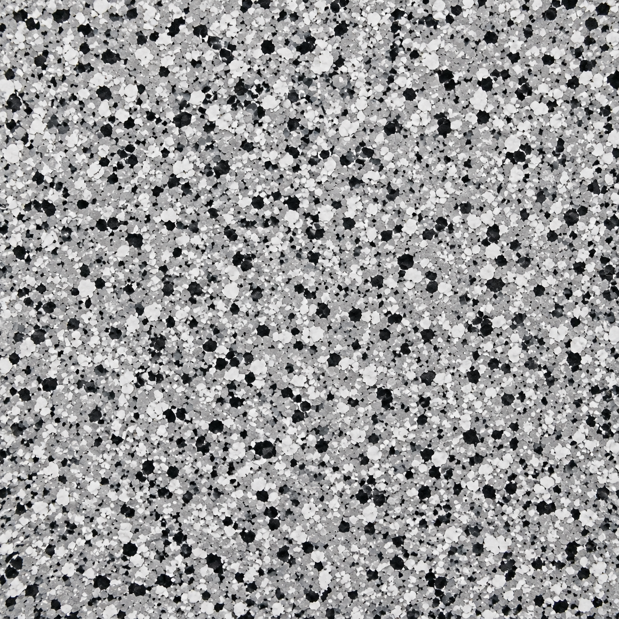 Close-up of a glittery surface with silver, white, and black specks