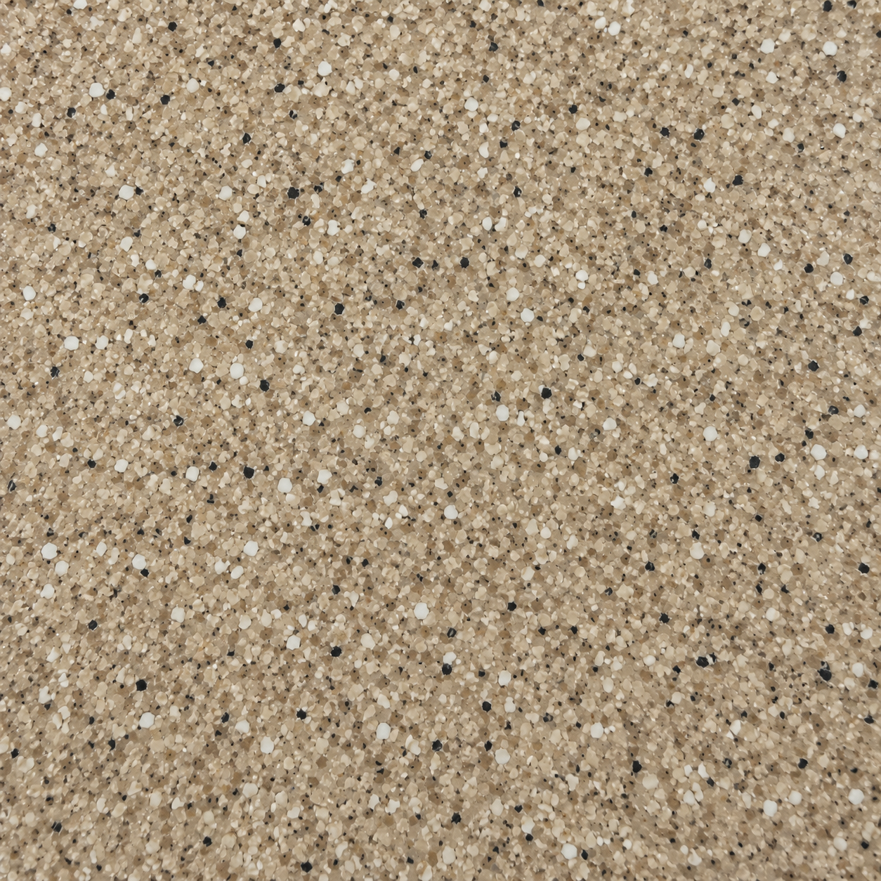 Close-up of tan and beige speckled sand with small white and black grains