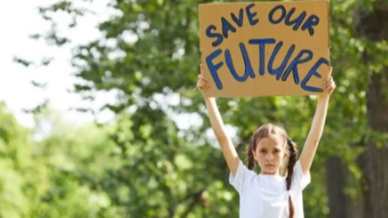 Young girl holding up sign: save our future