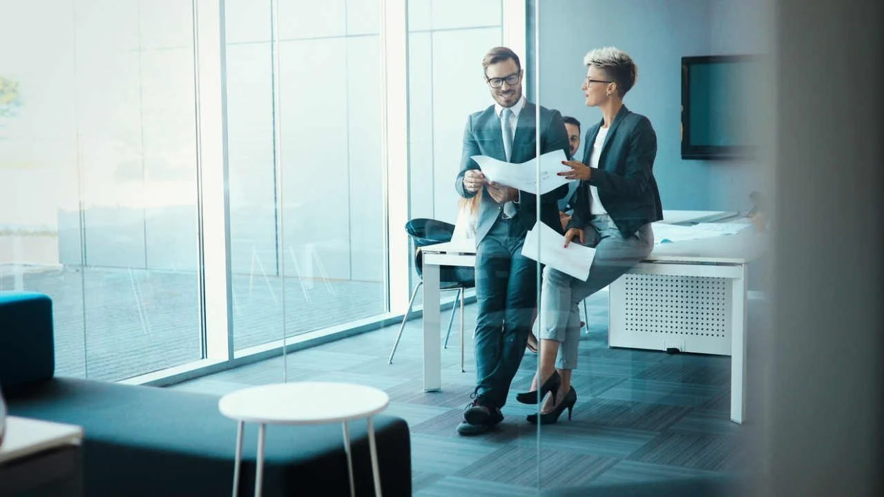 Man and woman discussing a report in office