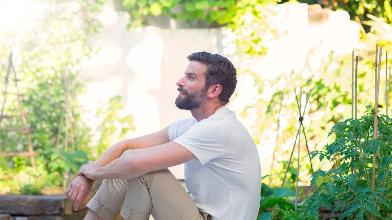 Man sitting and smiling in green garden