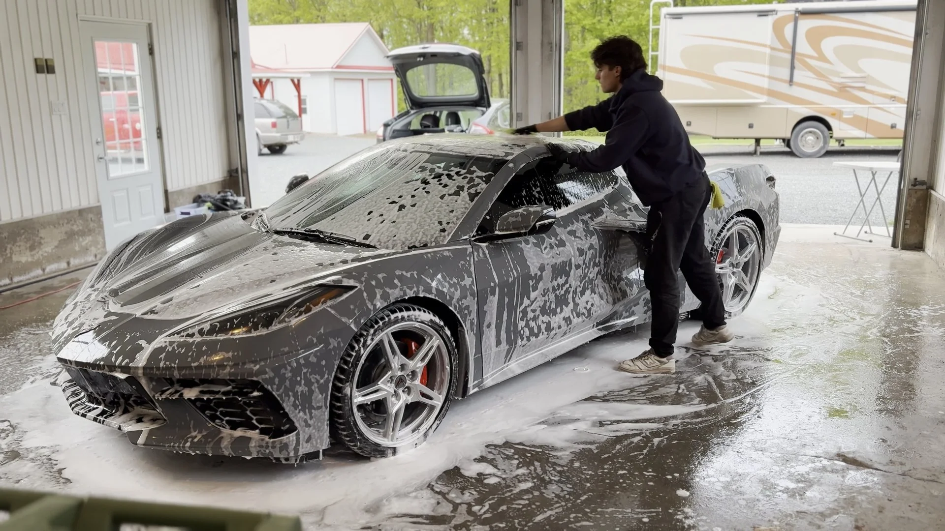 Personne lava une voiture de luxe, une Corvette, dans un garage avec beaucoup de mousse à savon.