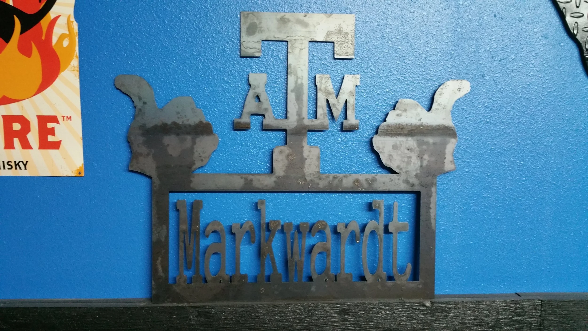 A metal sign that reads "I AM IMPORTANT" with a thumbs-up and a thumbs-down icon on a blue wall. Part of a colorful poster is visible on the left side.