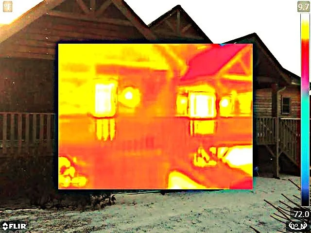 Thermal image of a house showing warm areas around windows and roof over a regular house with a porch, with a temperature scale on the right.