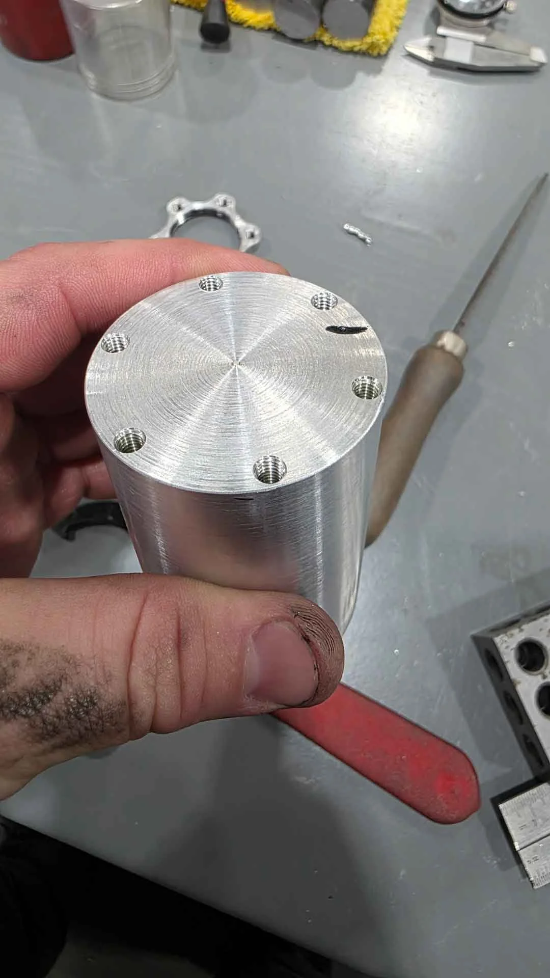 A precision machined cylinder component custom engineered with multiple threaded receptacles