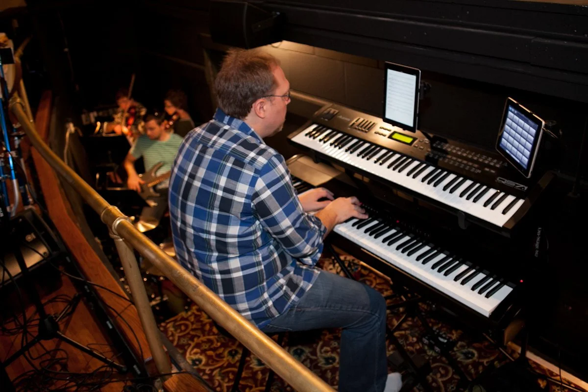 Piano instructor accompanying performers during live performance training at Hickory Arts in Hickory, North Carolina.