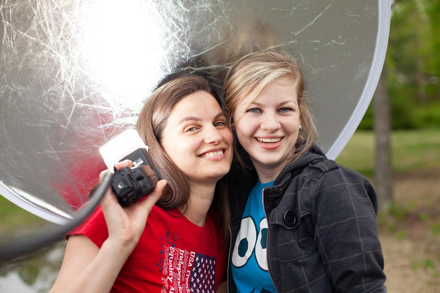 Photography student Darbey Roberts posing outdoors with a DSLR camera during a creative portrait session at Hickory Arts in North Carolina.
