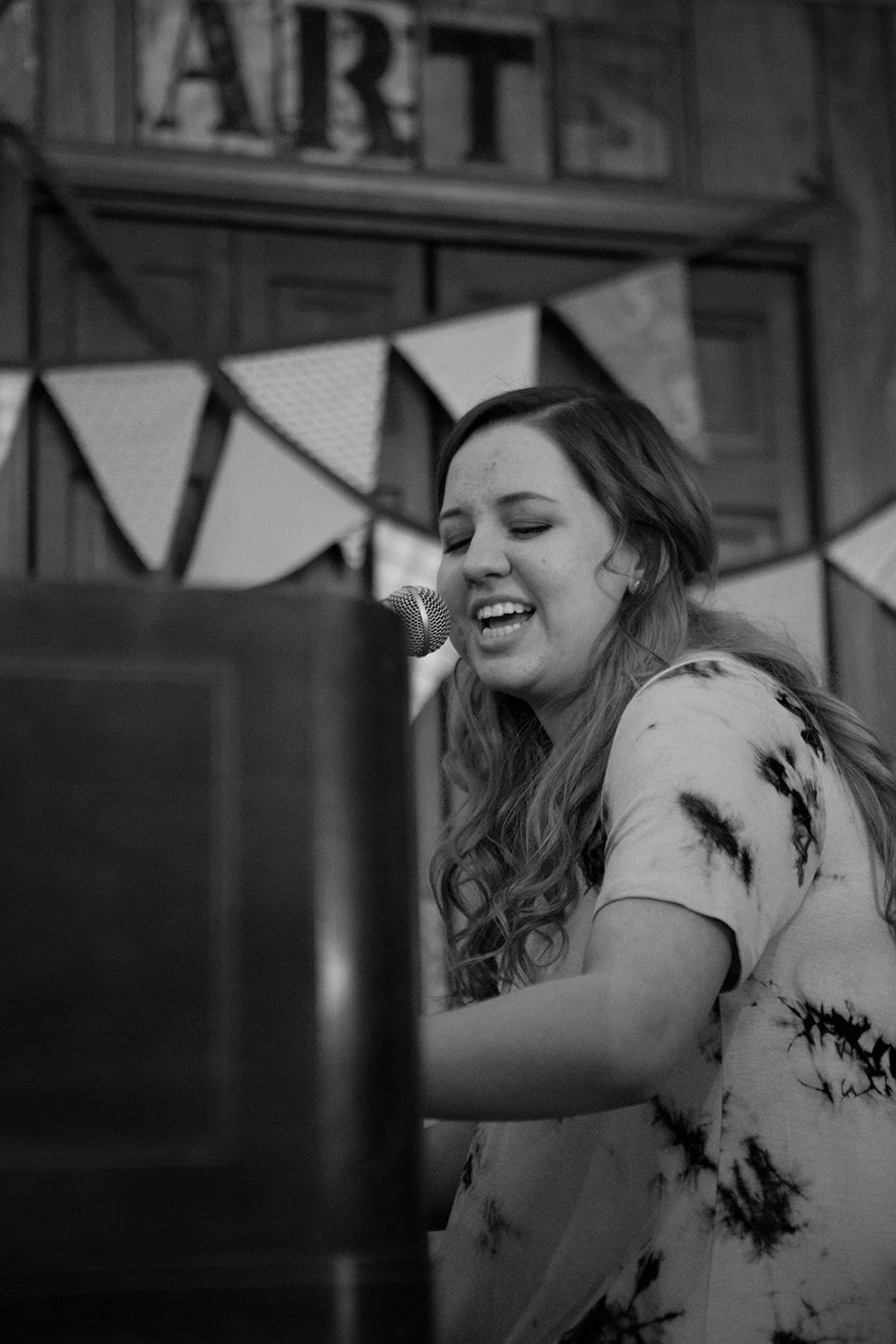Clowee Issabelle singing and playing piano during a Hickory Arts House Concert performance in Hickory, NC.