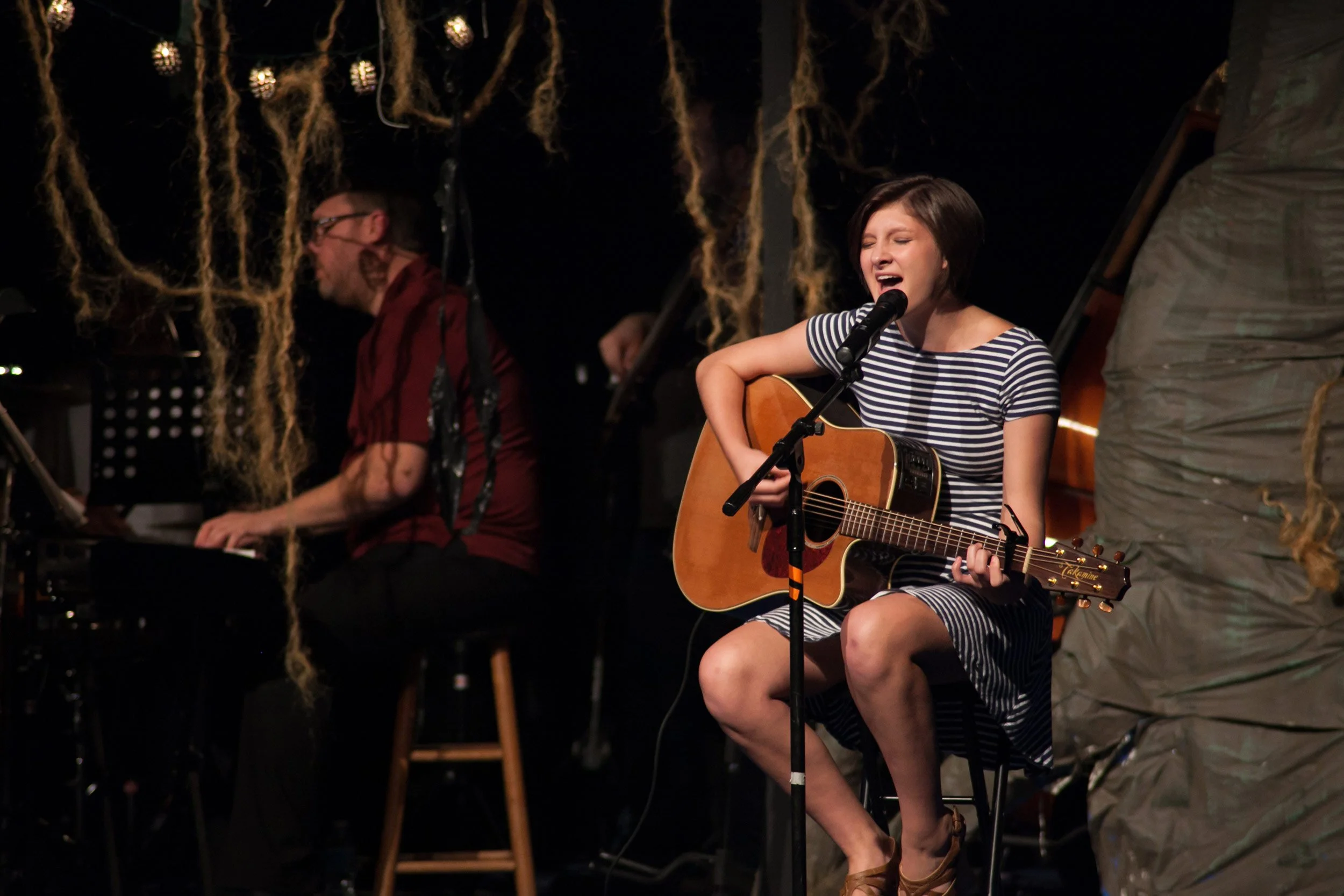 Young singer-songwriter performing with acoustic guitar during artist development showcase at Hickory Arts in Hickory, NC.