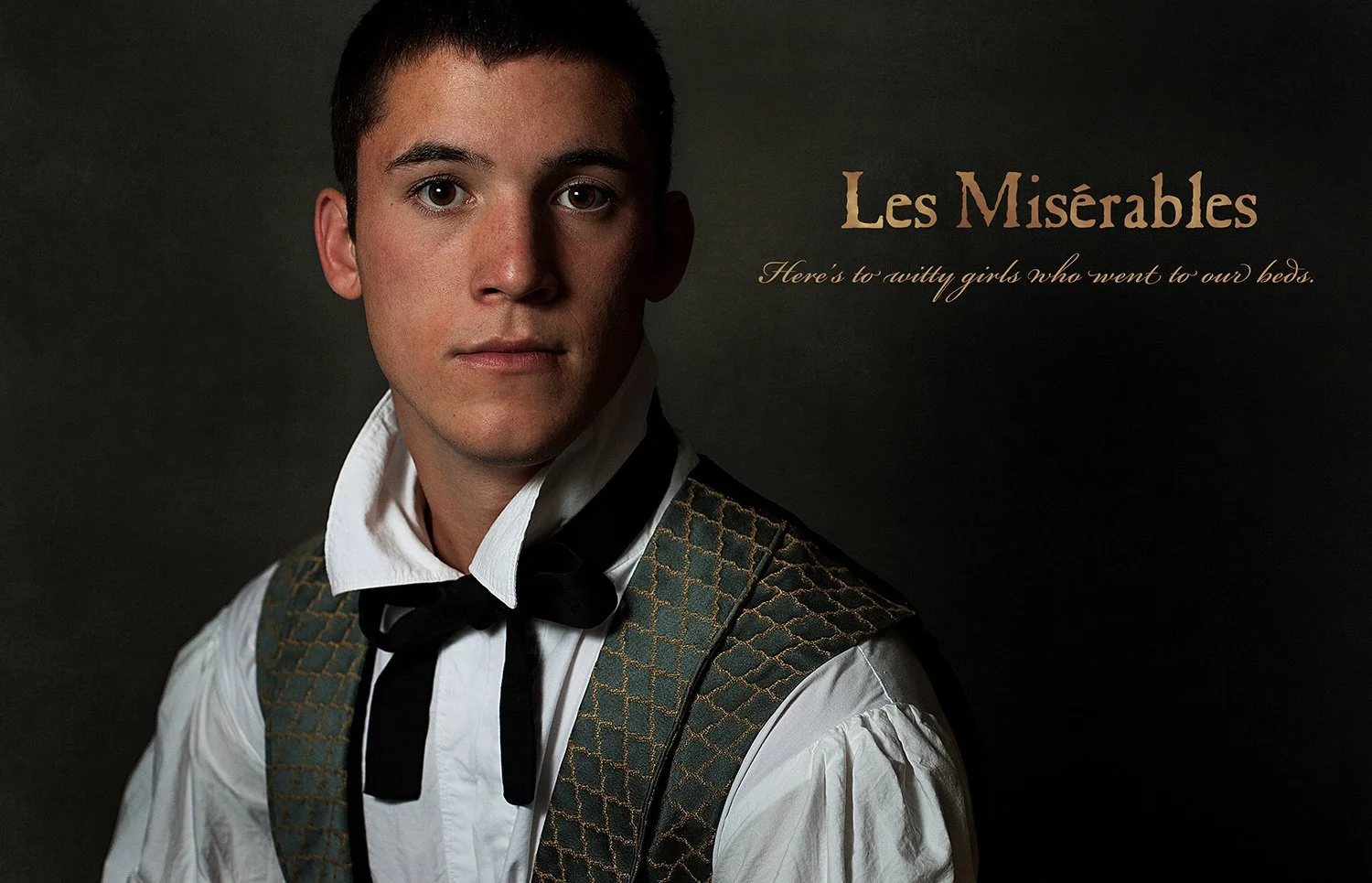 Young man dressed in costumes inspired by 'Les Misérables,' featuring a white shirt, black bow tie, and patterned vest, with dark background and text that reads 'Les Misérables' and 'Here's to witty girls who went to our beds.'