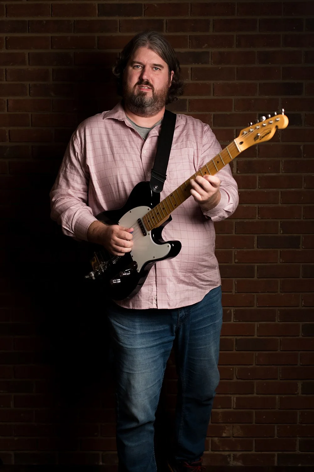 Electric guitar instructor William Knight posing with a black electric guitar at Hickory Arts in Hickory, NC.