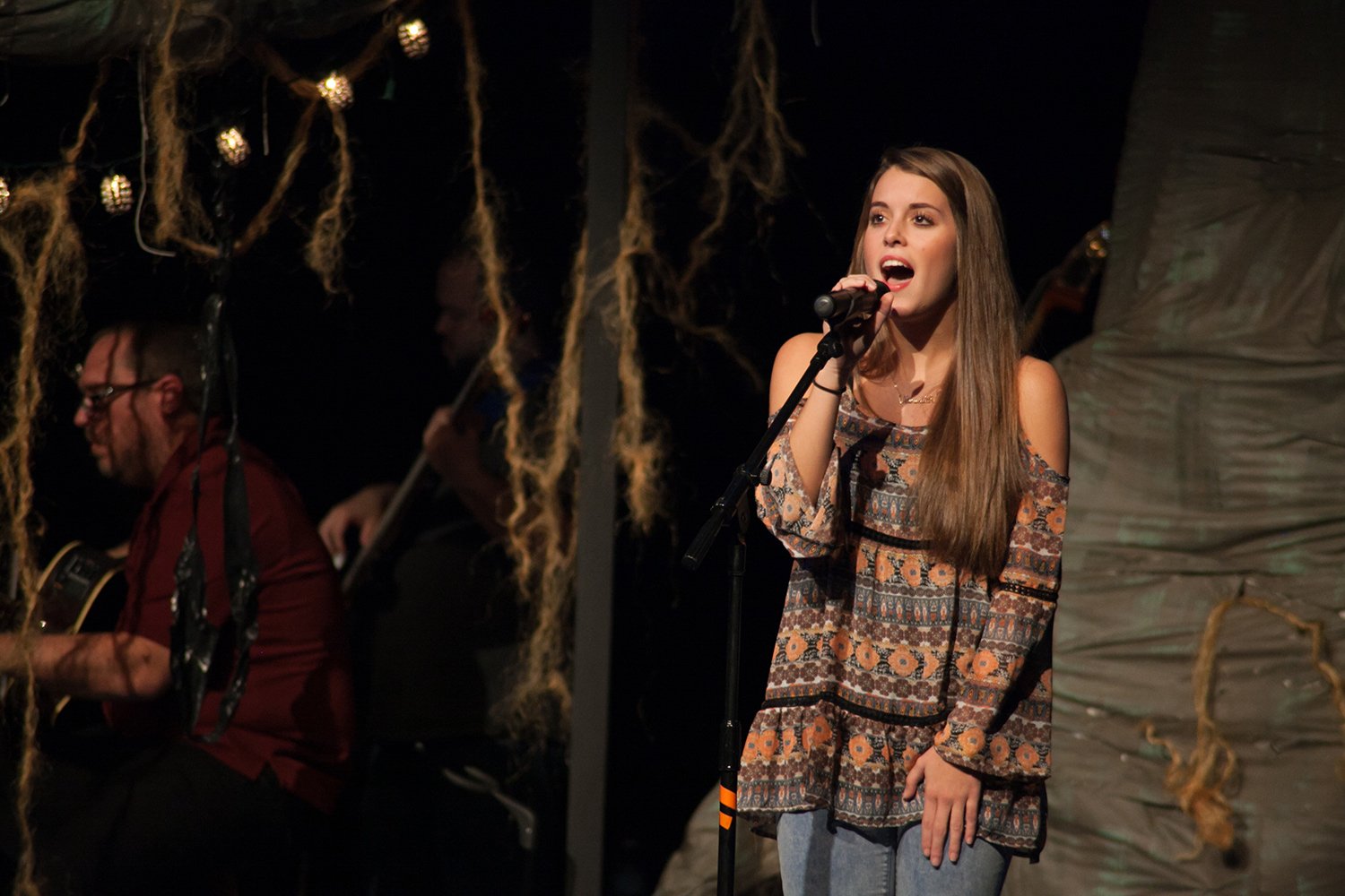 Student performing live vocals on stage during a Hickory Arts music performance in Hickory, NC.