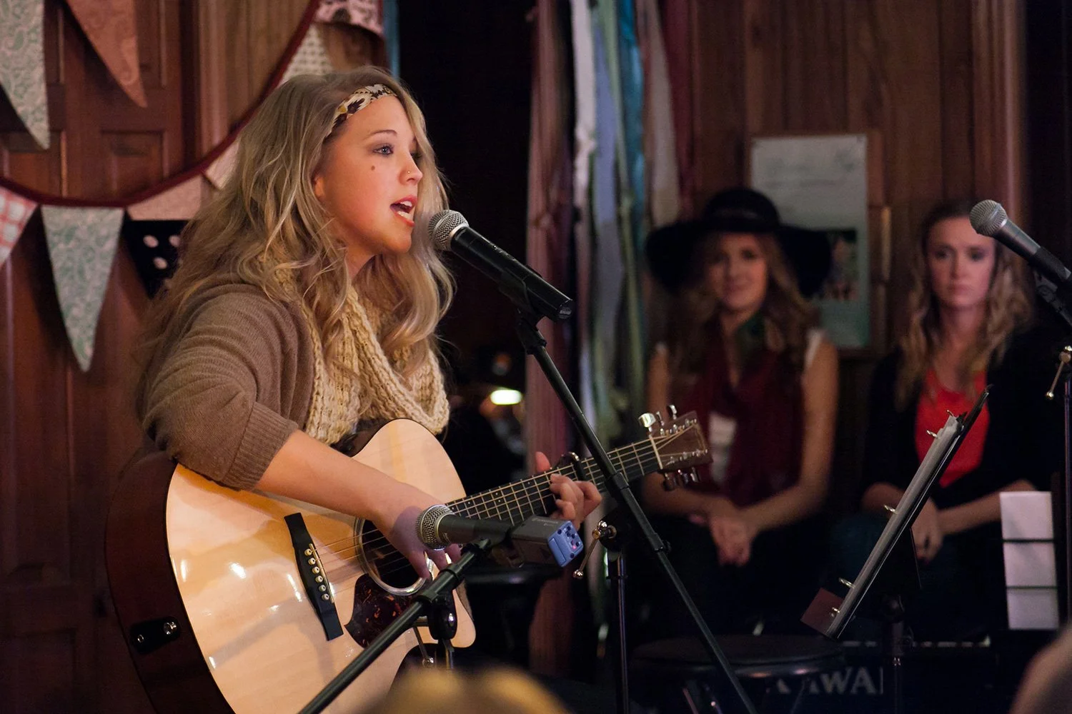 Tiffany Faucette performing an original song with acoustic guitar during a live songwriter performance after studying songwriting and artist development at Hickory Arts in Hickory, NC.