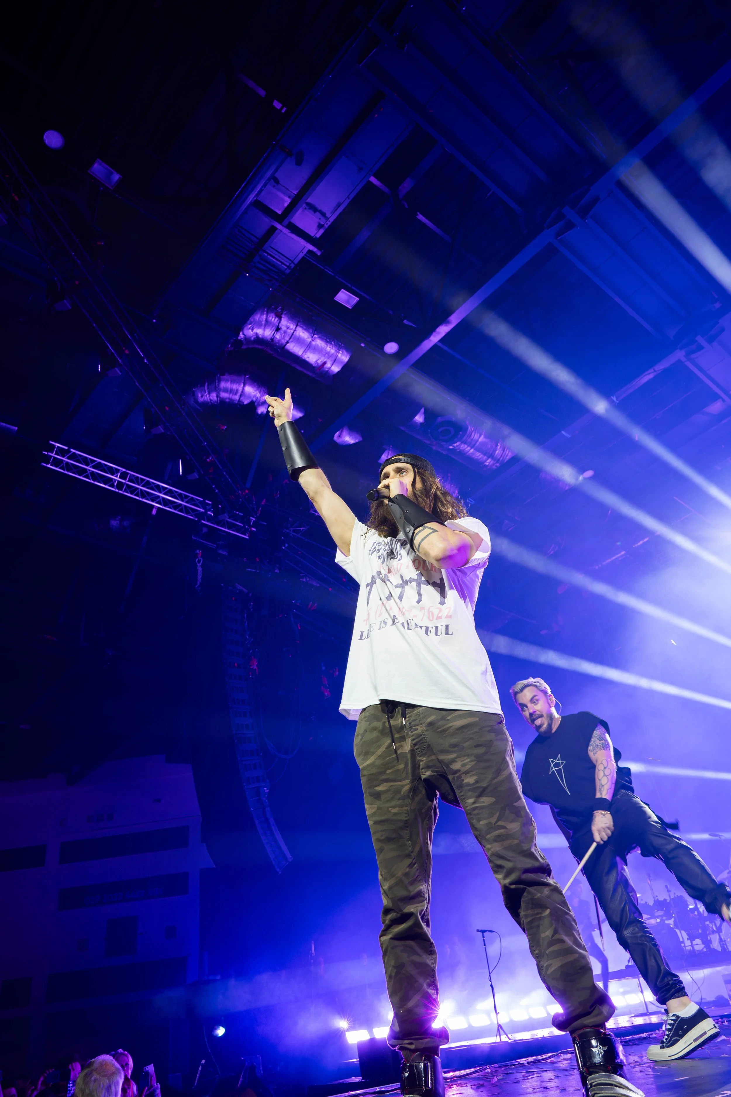 Jared Leto stood pointing up at a 30 Seconds to Mars Concert in Cardiff's Utilia Arena. 