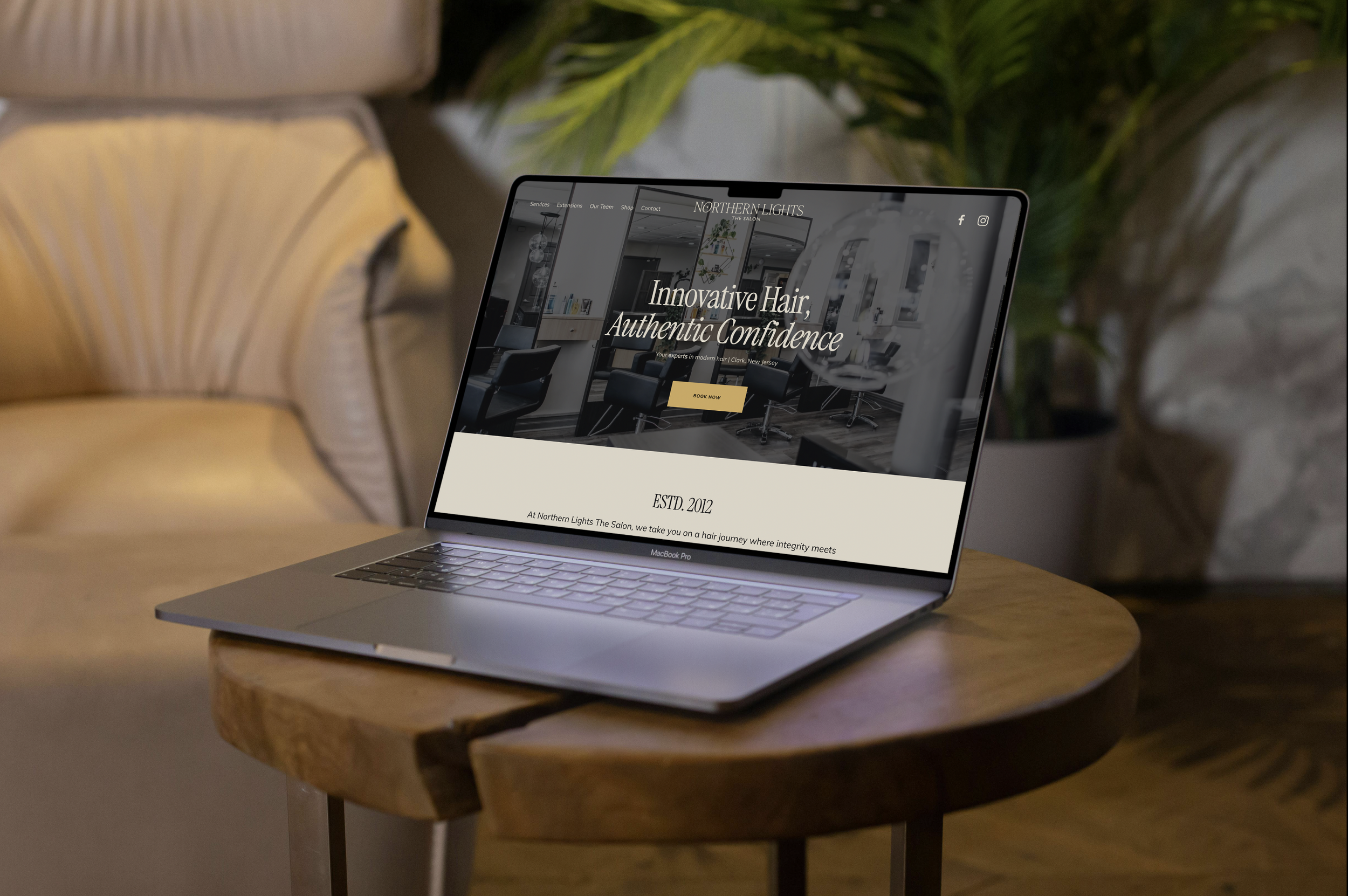 A laptop on a wooden table displaying a webpage for Northern Lights The Salon. The webpage features the text 'Innovative Hair, Authentic Confidence' and a book now button, with a salon interior background.