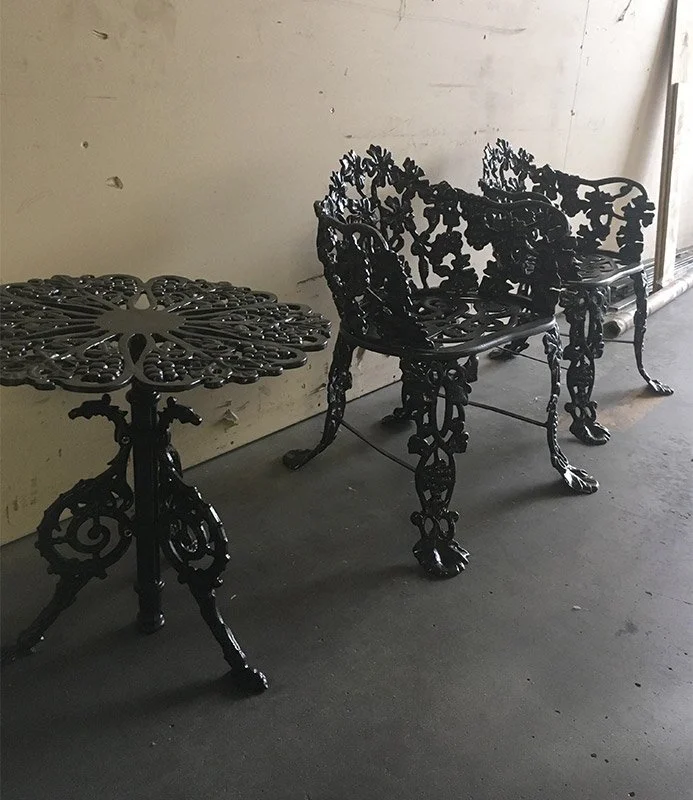 Black powder coated ornate cast iron bench and matching table.
