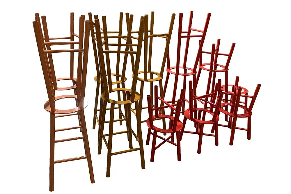A group of metal chairs in red, brown, and natural wood colors.