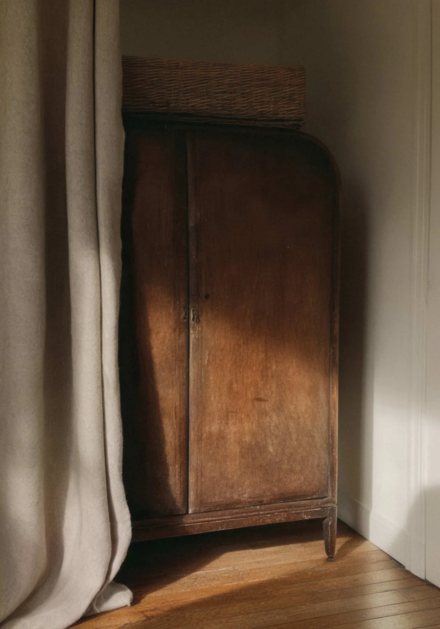 Vintage wooden armoire in shadow and sunlight.