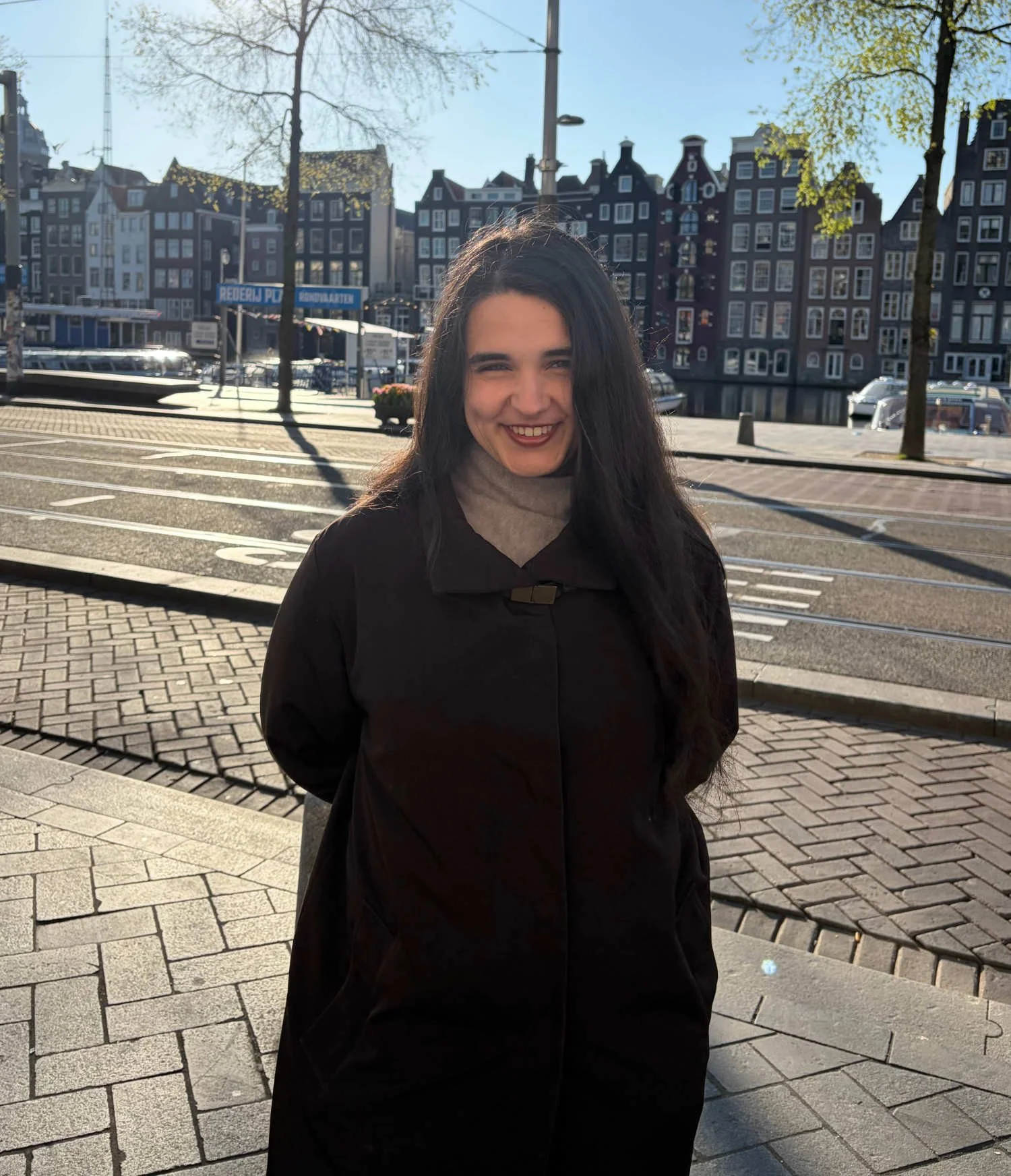 Julianne Baron, the founder standing in front of Dutch houses in Amsterdam.