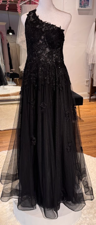 Black strapless evening gown with lace and floral appliqué details on the bodice, flowing tulle skirt.