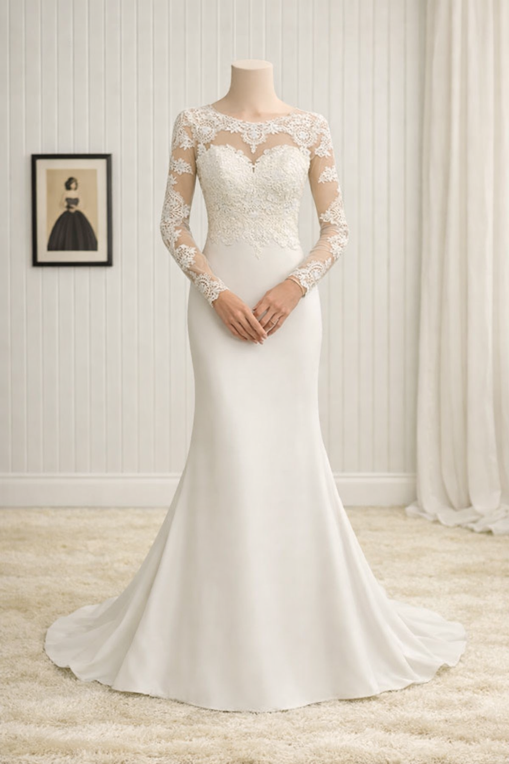 A mannequin wearing a long, elegant white wedding gown with lace embroidery on the bodice and sleeves, standing in a room with white paneled walls and beige carpet. There is a black picture frame with a vintage-style illustration of a woman in a blac