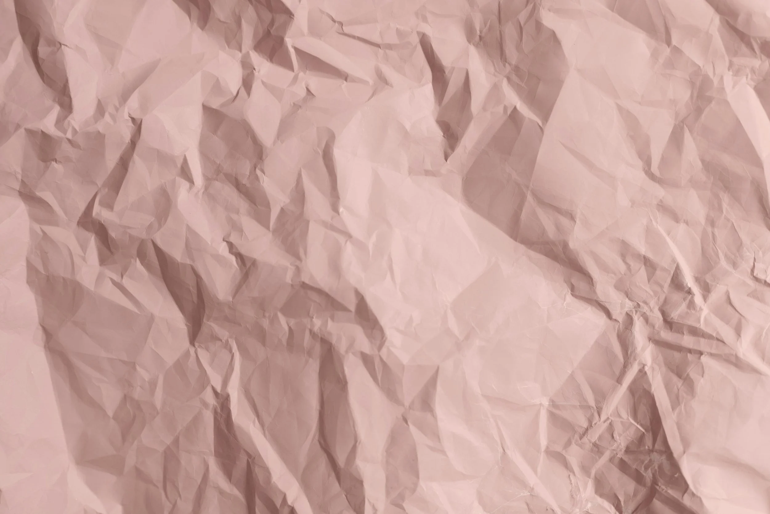 A crumpled sheet of light pink paper.