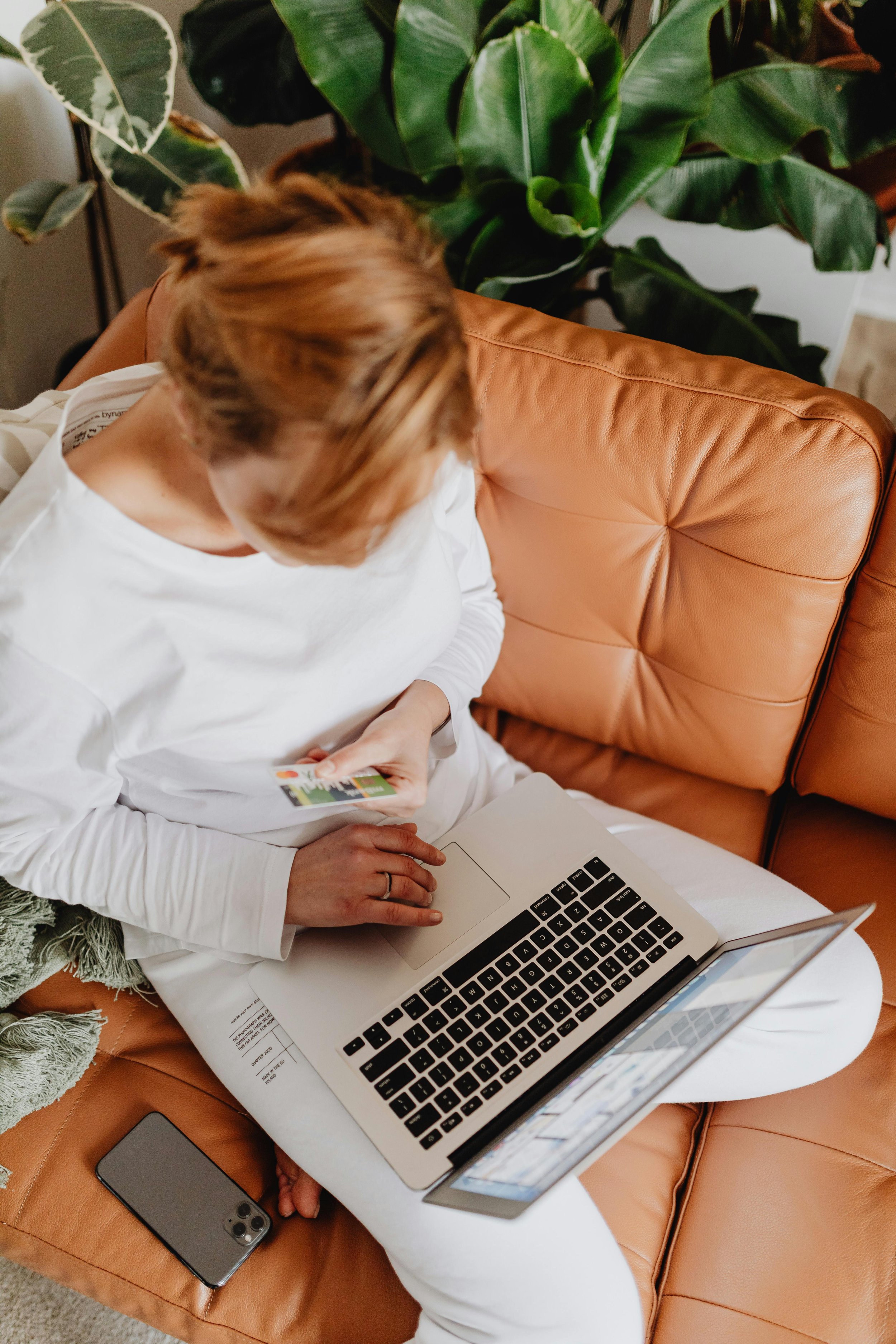 Creative agency owner reviewing business finances while sitting on a couch.