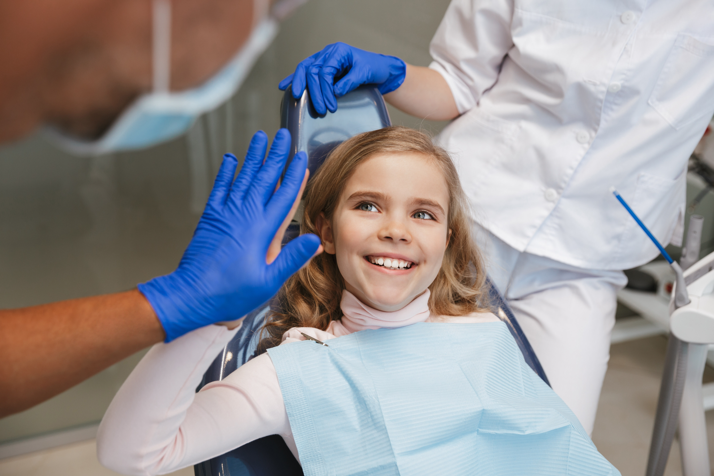 Happy child high-fives her dentist, showing a positive and anxiety-free dental experience.