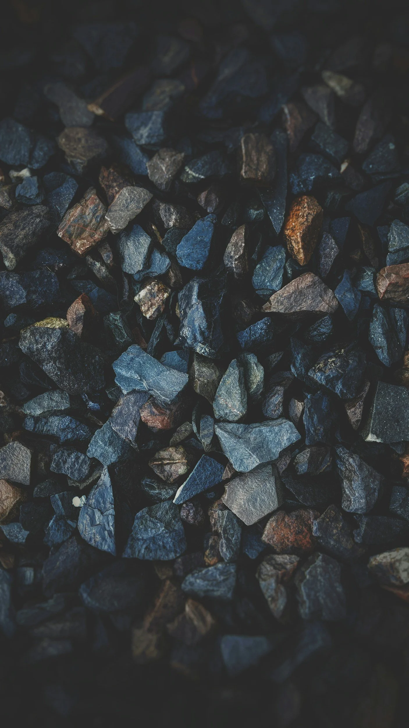 Close-up of small, dark, irregularly shaped rocks or gravel.