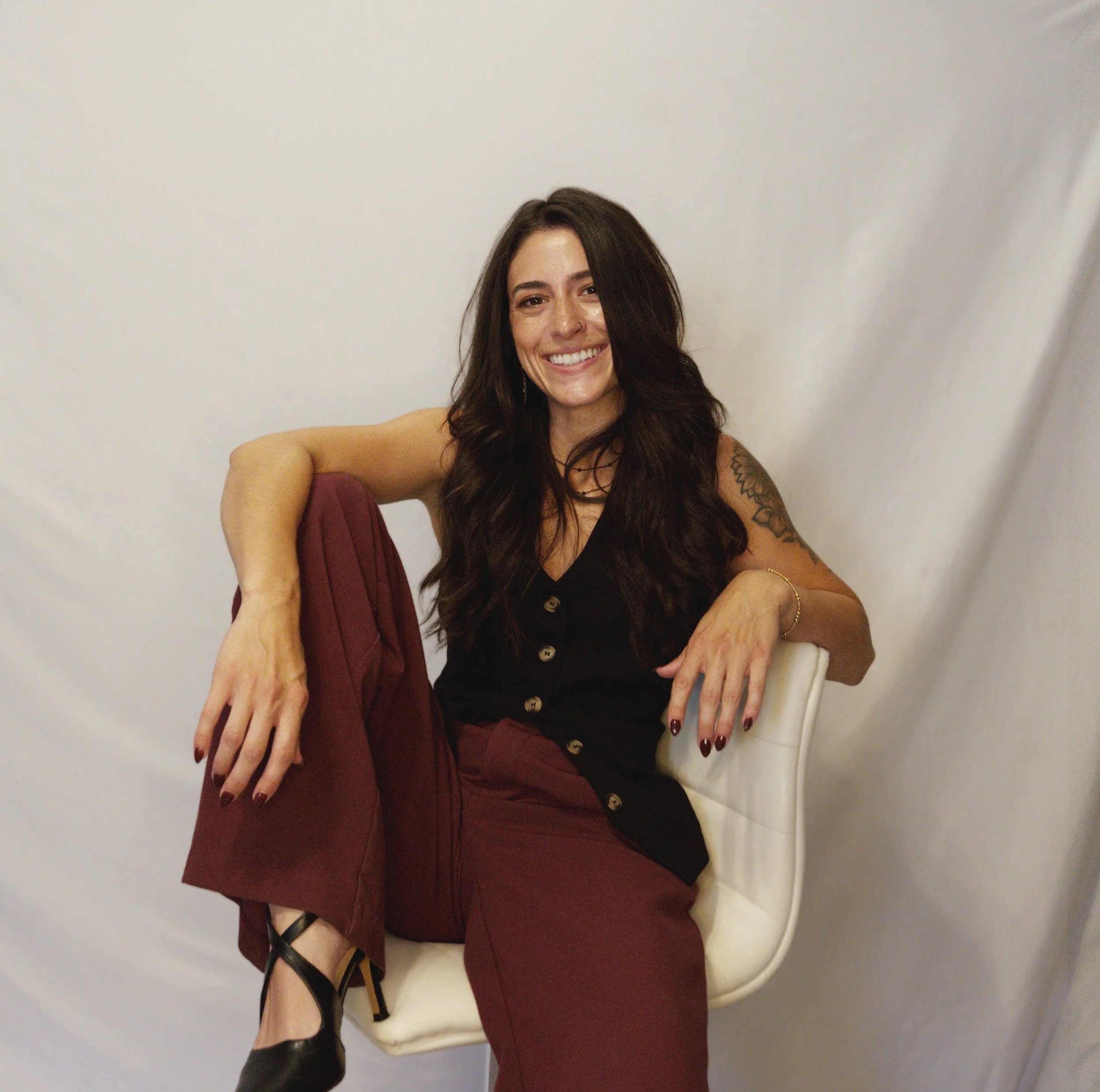 Amber Monaco, Phoenix commercial real estate agent with The Broker Reserve, smiling and seated in a modern chair