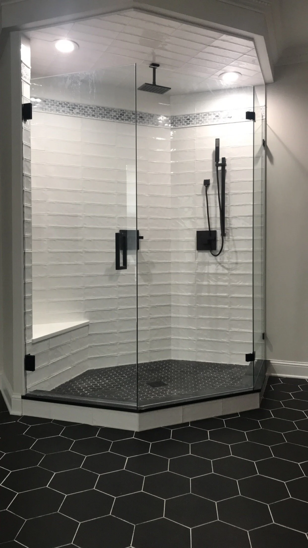 Neo angle frameless glass shower with white subway tile and dark hex floor in Deer Park IL