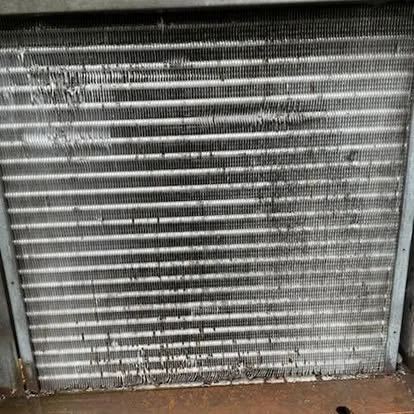 Close-up of a damaged metal radiator or vent with bent and broken slats.