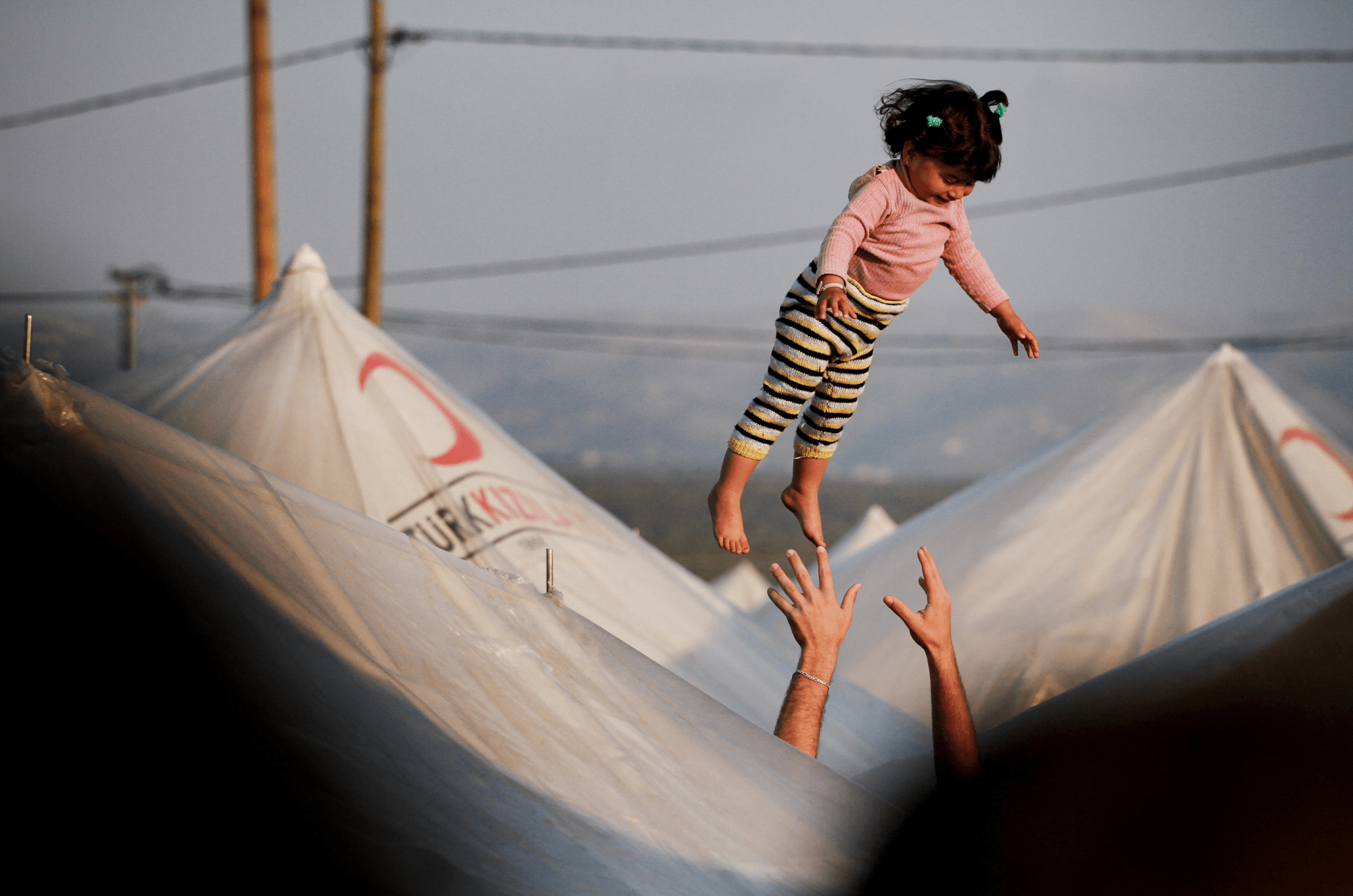  A man throws his daughter into the air inside a Syrian refugee camp 25km from Antakya in southern Turkey near the border with Syria, in Boynuyogun, Turkey, March 27, 2012. (Photo Credit/Tara Todras-Whitehill) 