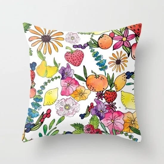 Decorative pillow with a colorful floral and fruit pattern on a white background.