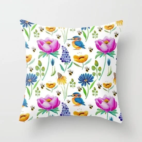 Decorative pillow with a colorful floral and bird pattern including pink flowers, blue flowers, yellow flowers, birds, and bees on a white background.