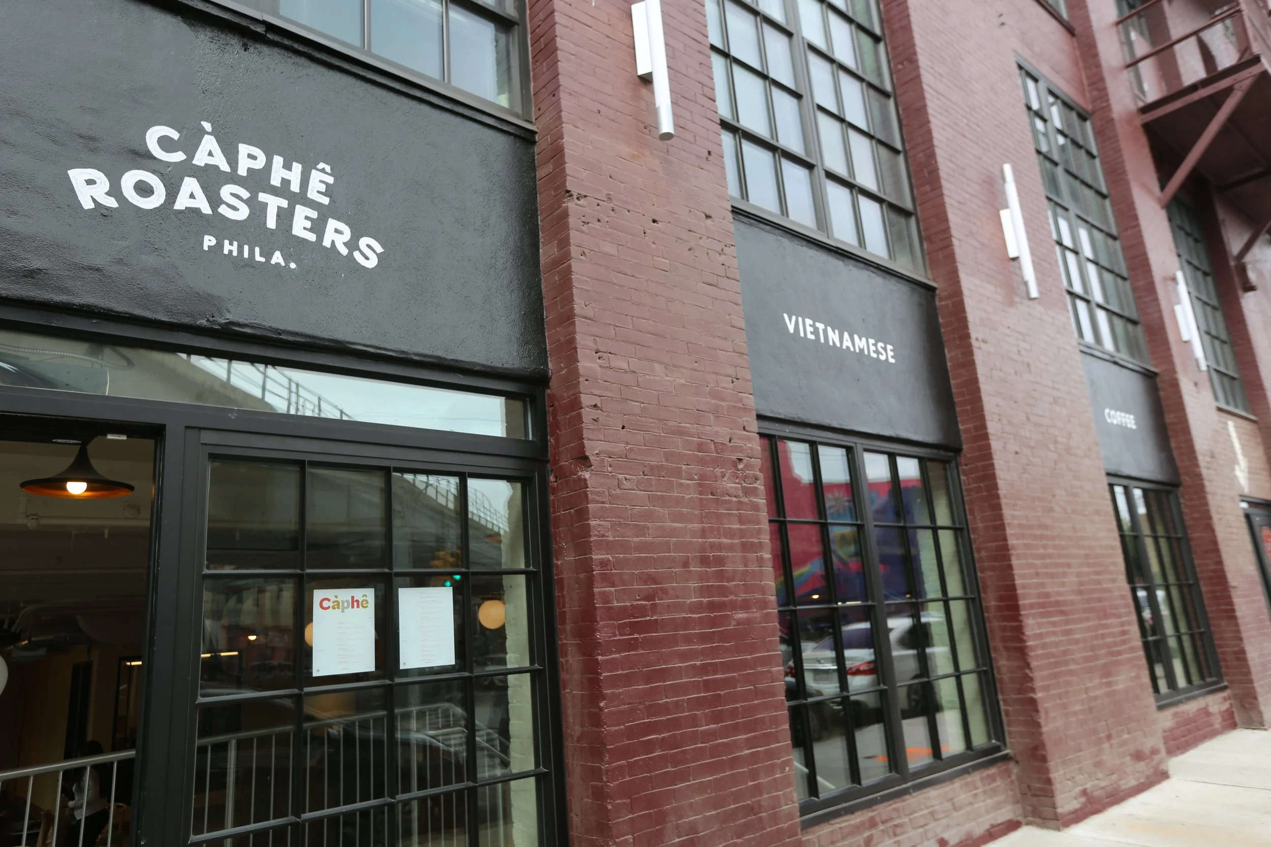 Image of exterior of Caphė Roasters, a local coffee bean roastery, cafe and restaurant at J-centrel in Philadelphia