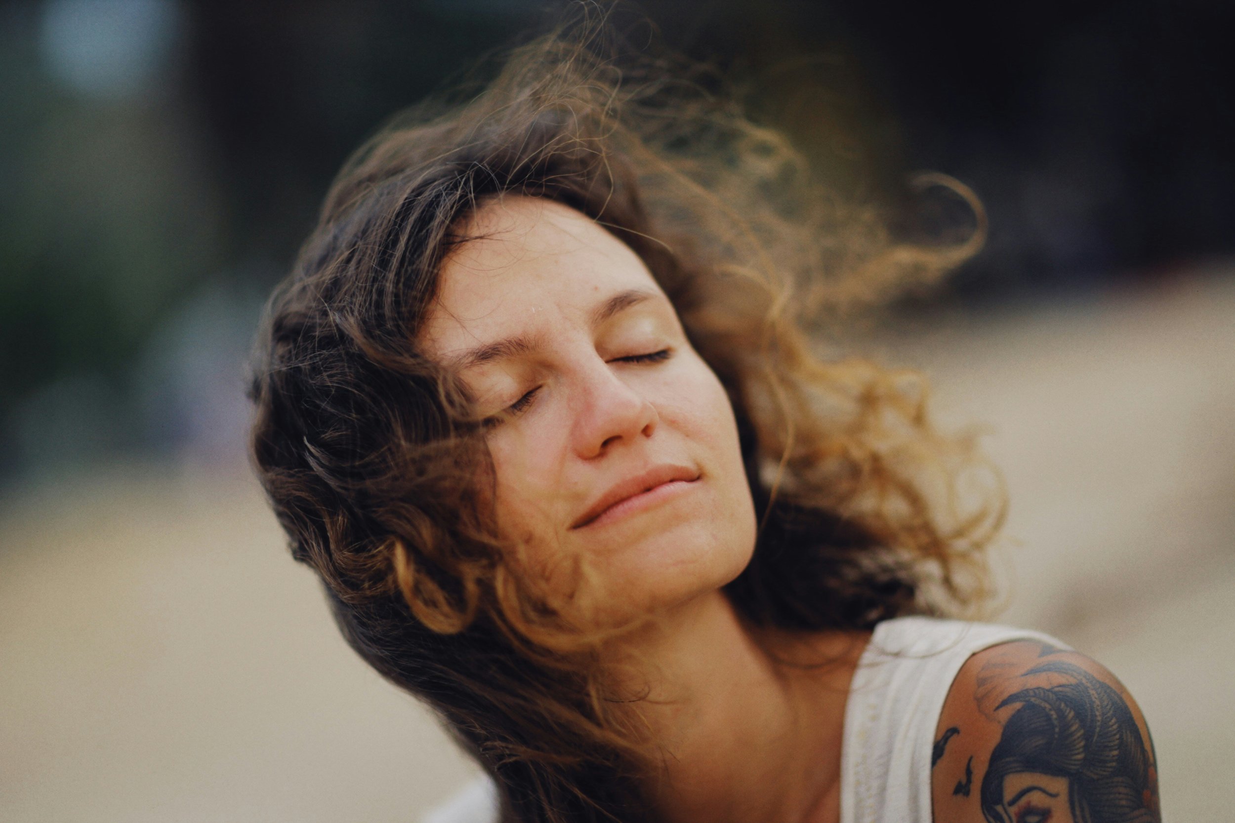 Person peacefully reflecting outdoors, representing emotional openness and expanded awareness during a guided psilocybin journey.