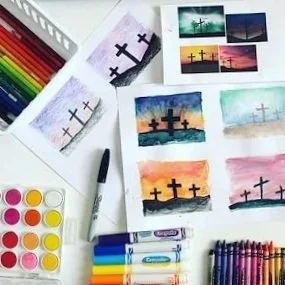 A collection of watercolor paintings of crosses at sunset, with art supplies including colored pencils, watercolor paints, a black pen, and brushes around them.