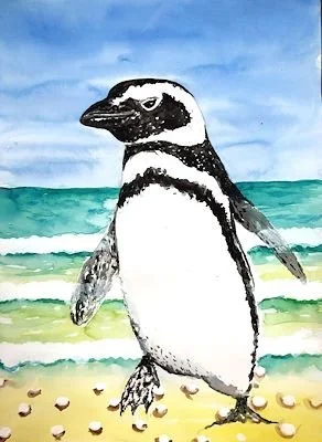 A penguin standing on a beach with waves in the background.