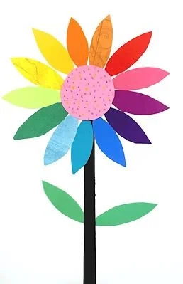 Colorful paper flower with multicolored petals, a pink dotted center, a black stem, and two green leaves.