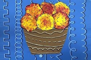 A bowl filled with golden-brown fried food, possibly croquettes or cheese balls, placed on a blue patterned cloth.