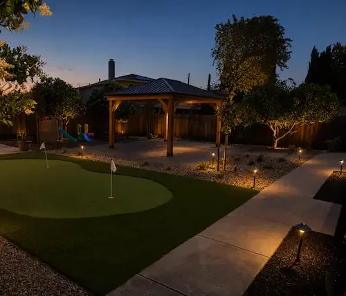 Backyard with artificial turf putting green, walkway lighting and entertaining area in Danville, CA