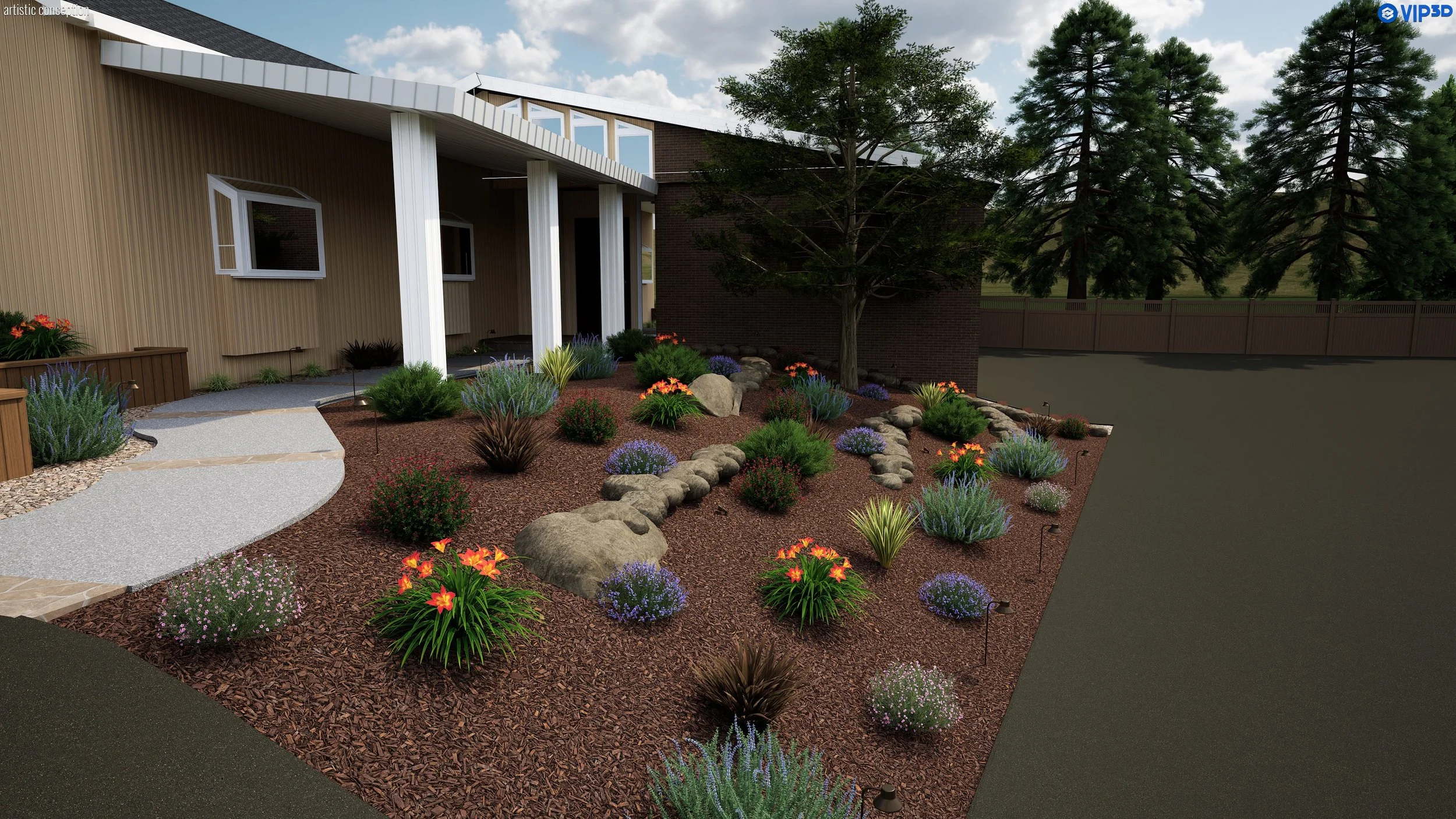 A landscaped front yard with a curved pathway, various colorful flowers, green shrubs, large rocks, and tall trees behind a modern house with tan siding and white accents. A wooden fence borders the yard in the background.