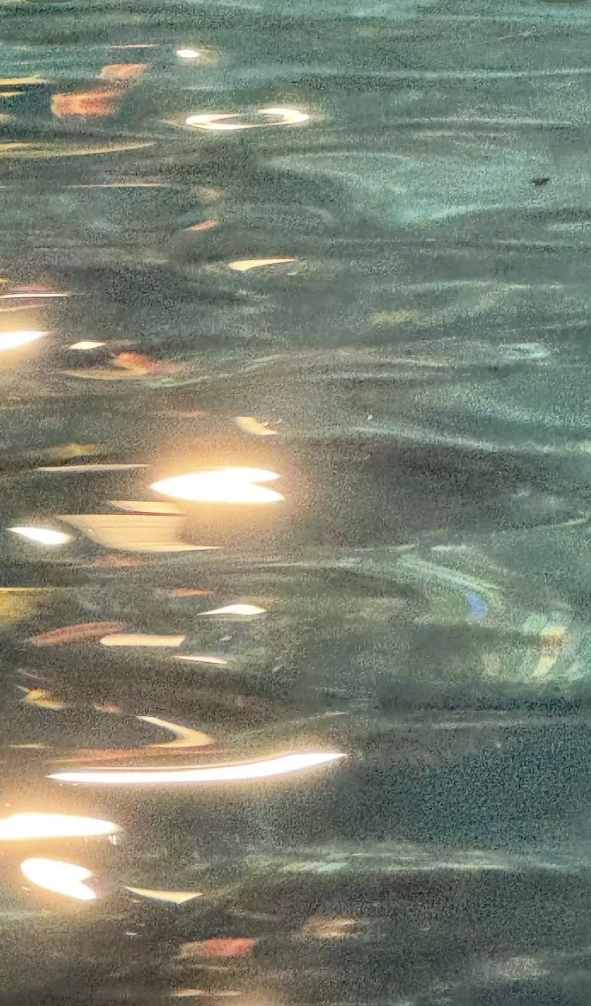 Reflections of city lights on a rainy street at night.