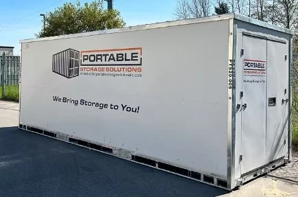 Large white portable storage container with company logo and slogan, placed outdoors on a paved surface.